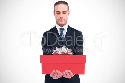 Composite image of concentrated businessman holding out his hand