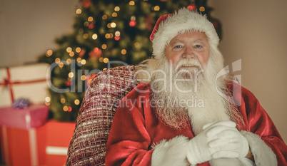 Smiling santa claus relaxing on the armchair