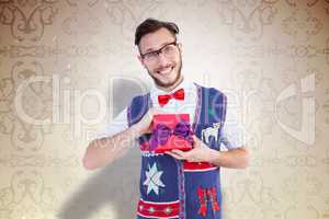 Composite image of geeky hipster offering christmas gift