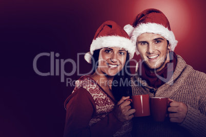 Young festive couple holding mugs