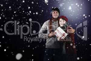 Composite image of couple smiling and holding gift