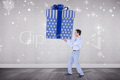 Composite image of stylish man with giant gift