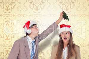 Composite image of geeky hipster with mistletoe