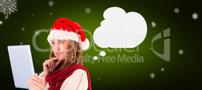 Composite image of festive blonde looking at tablet pc