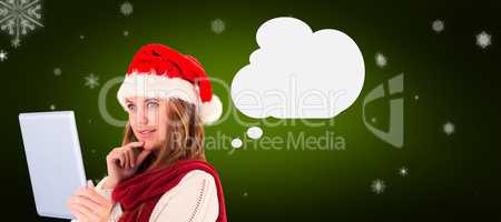 Composite image of festive blonde looking at tablet pc