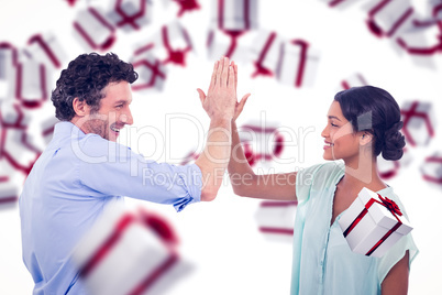 Composite image of business people high fiving over white backgr