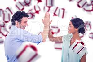 Composite image of business people high fiving over white backgr