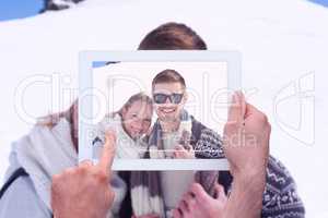 Composite image of hand holding tablet pc