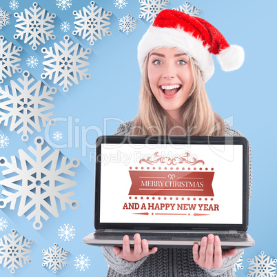 Composite image of festive blonde holding a laptop