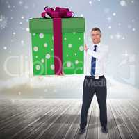 Composite image of stylish man with giant gift