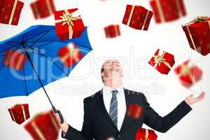 Composite image of happy businessman holding blue umbrella and l