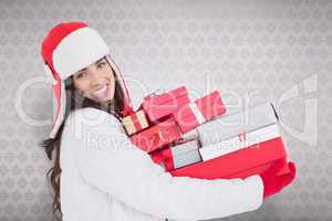 Composite image of festive brunette in winter clothes holding ma
