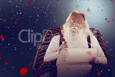 Composite image of father christmas writing list with a quill