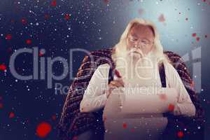 Composite image of father christmas writing list with a quill