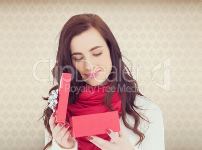 Composite image of pretty brunette opening christmas gift