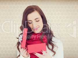 Composite image of pretty brunette opening christmas gift