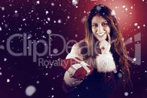 Composite image of festive redhead holding a gift