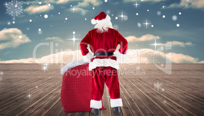 Composite image of santa with sack of gifts