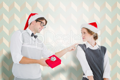 Composite image of geeky hipster offering present to his girlfri