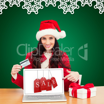 Composite image of festive brunette shopping online