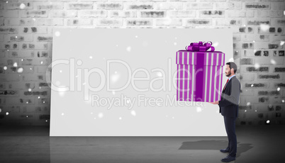 Composite image of stylish man with giant gift