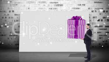 Composite image of stylish man with giant gift