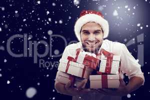 Composite image of festive man holding christmas gifts