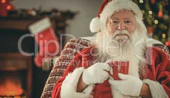 Smiling santa claus holding a mug