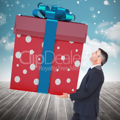 Composite image of stylish man with giant gift