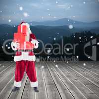 Composite image of santa carrying gifts