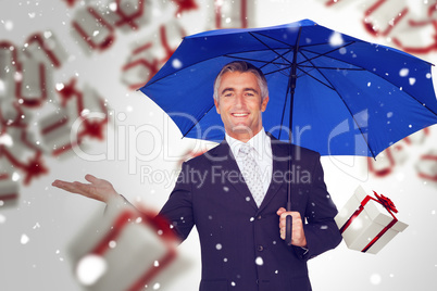 Composite image of smiling businessman holding blue umbrella wit