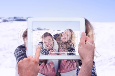 Composite image of hand holding tablet pc