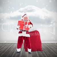 Composite image of santa holding pile of gifts