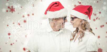 Composite image of festive couple smiling at each other