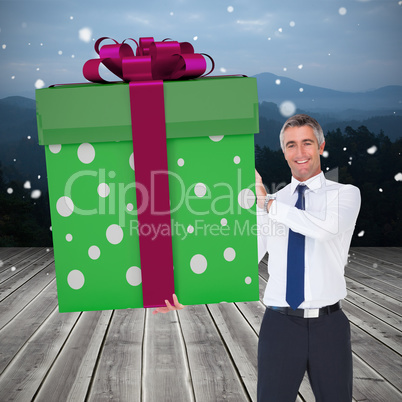 Composite image of stylish man with giant gift