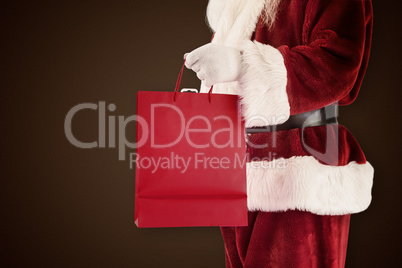 Composite image of santa carries red gift bag