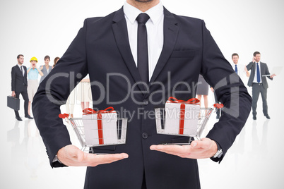 Composite image of mid section of a businessman holding somethin