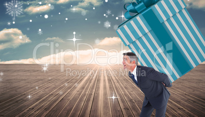 Composite image of stylish man with giant gift