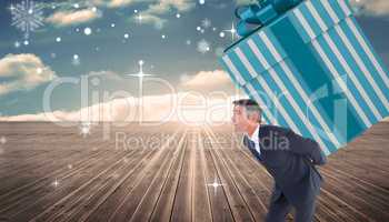 Composite image of stylish man with giant gift