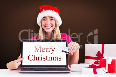 Composite image of festive blonde shopping online with laptop