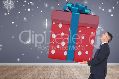 Composite image of stylish man with giant gift