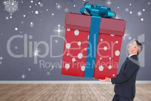 Composite image of stylish man with giant gift