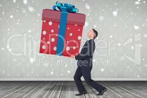 Composite image of stylish man with giant gift