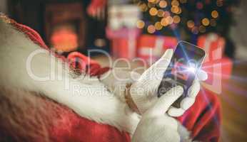 Santa claus touching a smartphone at christmas
