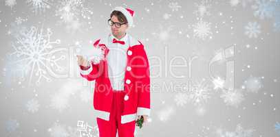 Composite image of geeky hipster in santa costume looking at beard