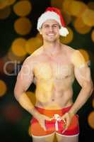 Composite image of smiling muscular man posing in sexy santa out