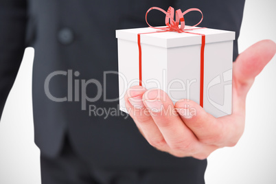 Composite image of businessman holding out his hand