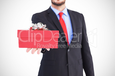 Composite image of businessman holding hand out in presentation