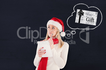 Composite image of festive blonde writing her christmas list