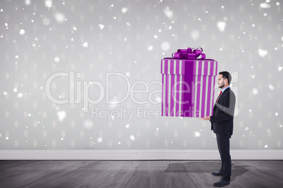 Composite image of stylish man with giant gift